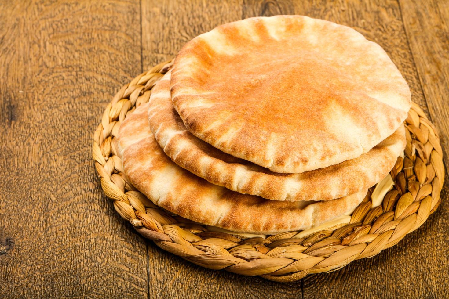 pão pita na tábua de madeira e fundo de madeira foto