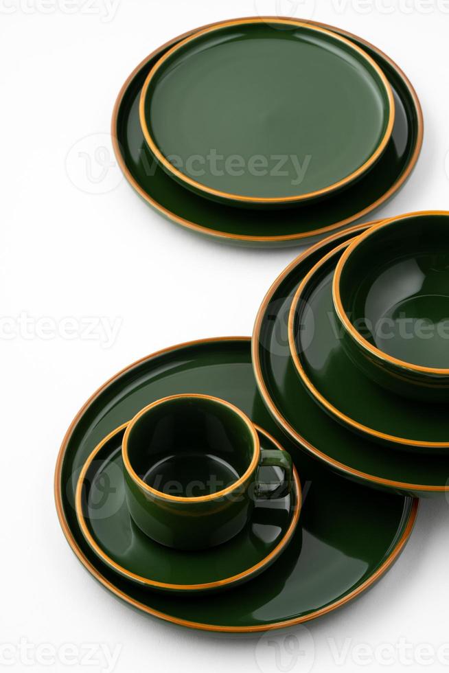 um conjunto de talheres de cerâmica verde escuro com contornos laranja em um fundo branco foto