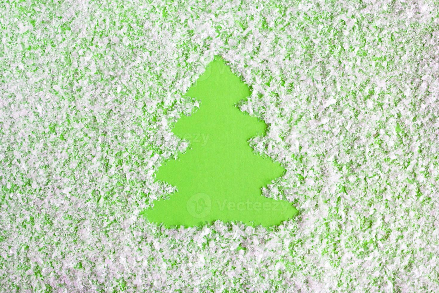 composição de inverno com árvore de natal em um fundo verde com neve artificial, postura plana. cartão de felicitações para o ano novo com espaço de cópia. foto