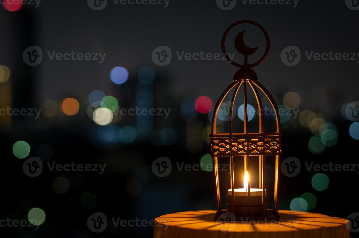 linda lanterna que tem o símbolo da lua no topo com luz bokeh da cidade em fundo escuro. foto