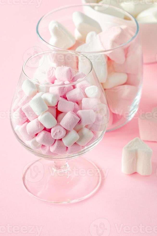 forma de coração de marshmallow e mini com conceito de amor no fundo rosa foto