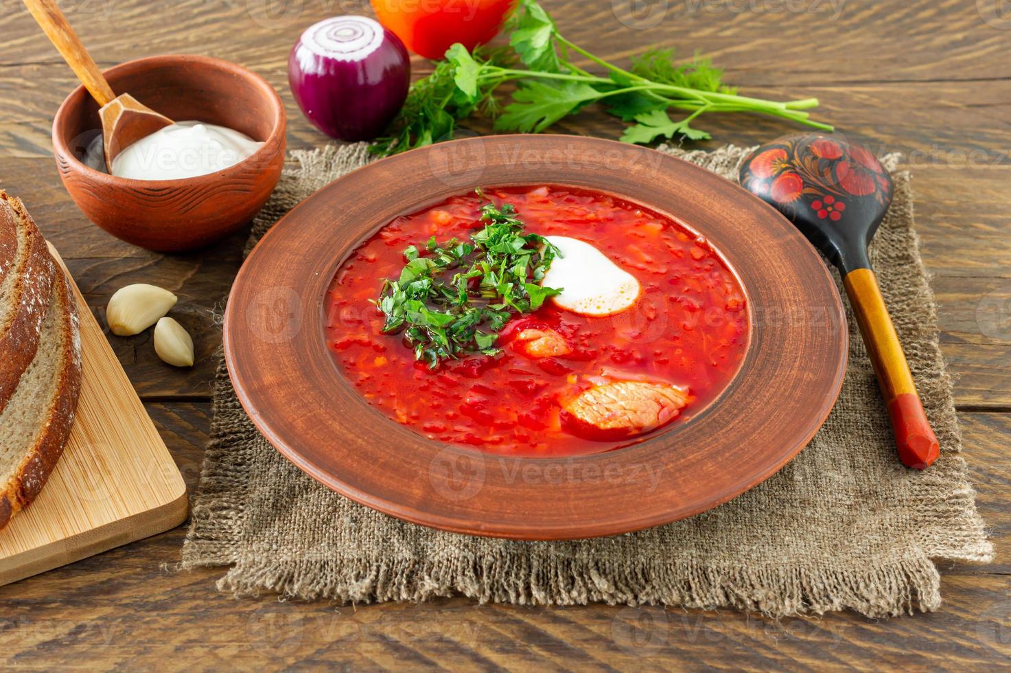 borsch - sopa de beterraba tradicional ucraniana e russa em fundo escuro de madeira. servido com pão de centeio, alho e sal foto