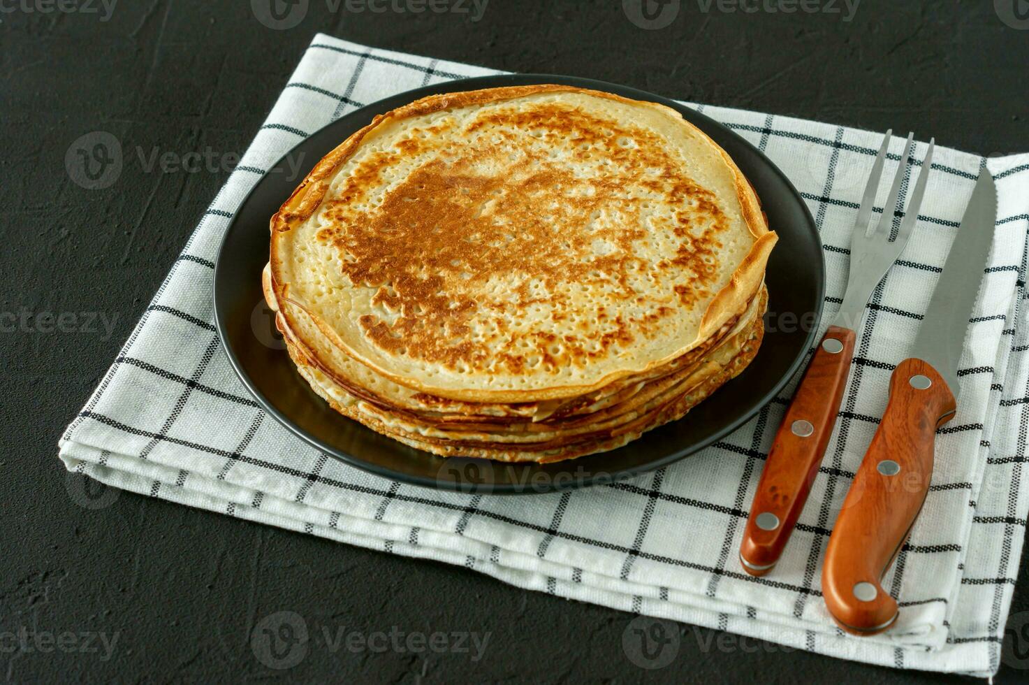 crepes ou blini russo em estilo rústico de fundo de madeira. crepes finos caseiros para café da manhã ou sobremesa. foto