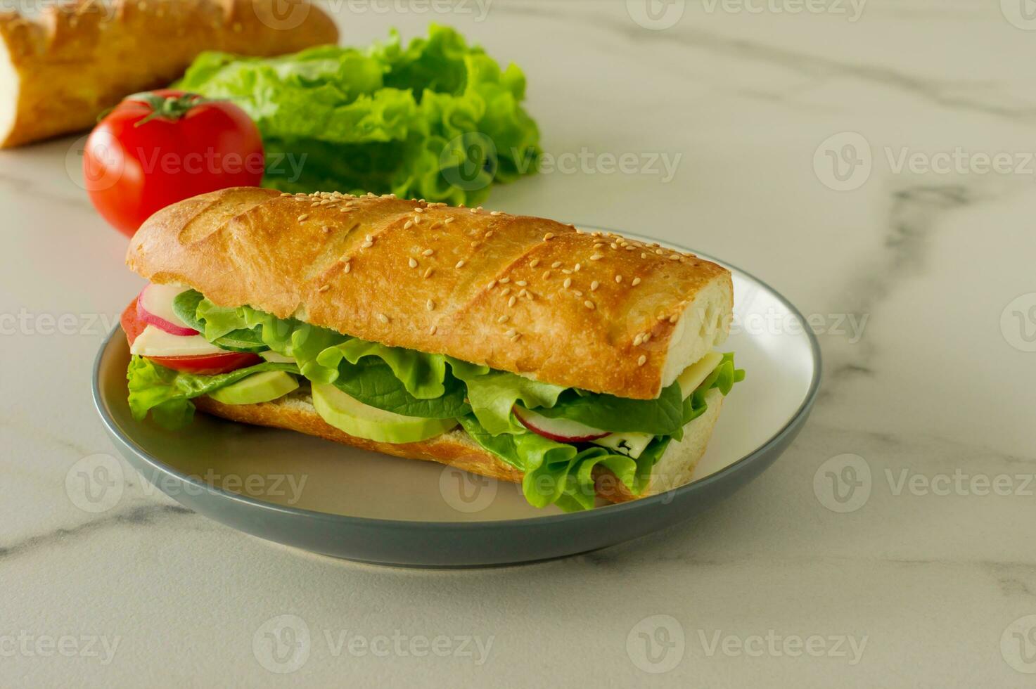 Sanduíche vegano de baguete longa integral com alface, abacate, tomate e queijo. lanche saudável e comida para viagem foto