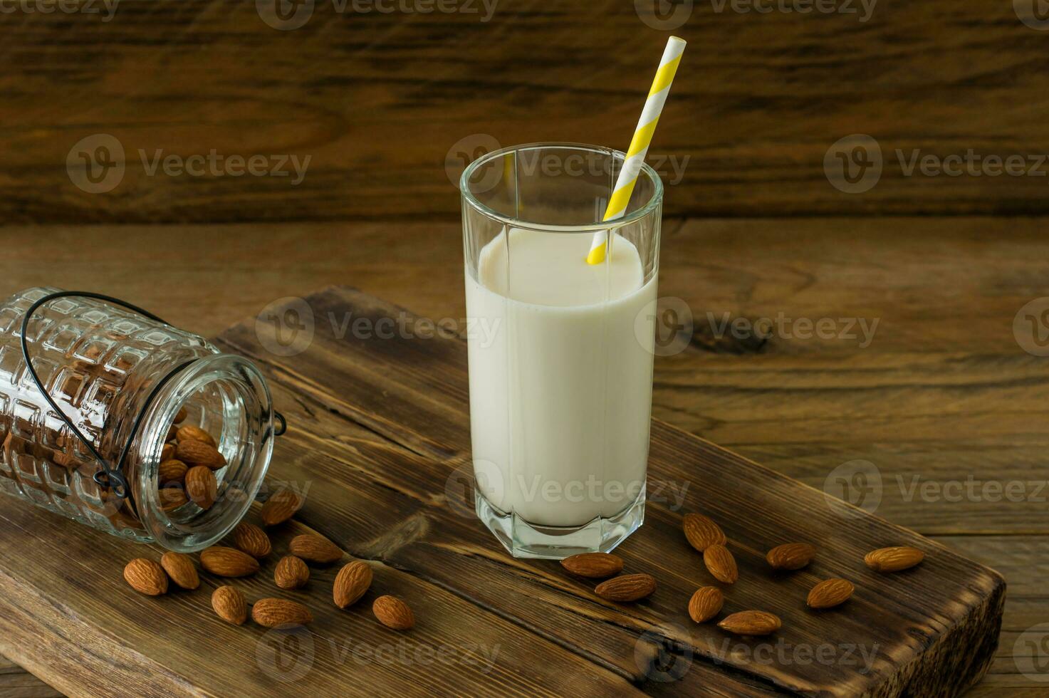 leite de amêndoa em vidro com amêndoas na mesa de madeira foto
