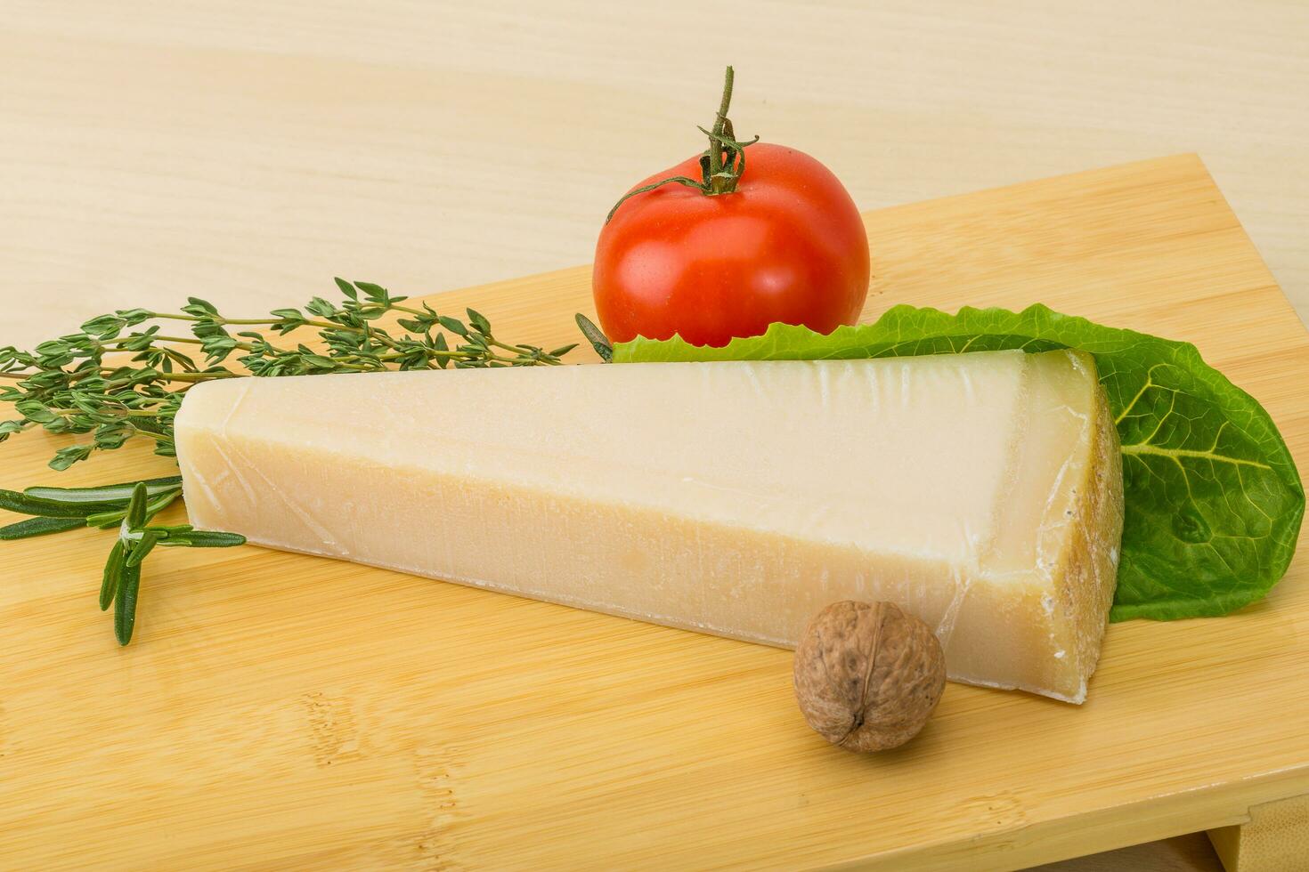 queijo parmesão na tábua de madeira e fundo de madeira foto