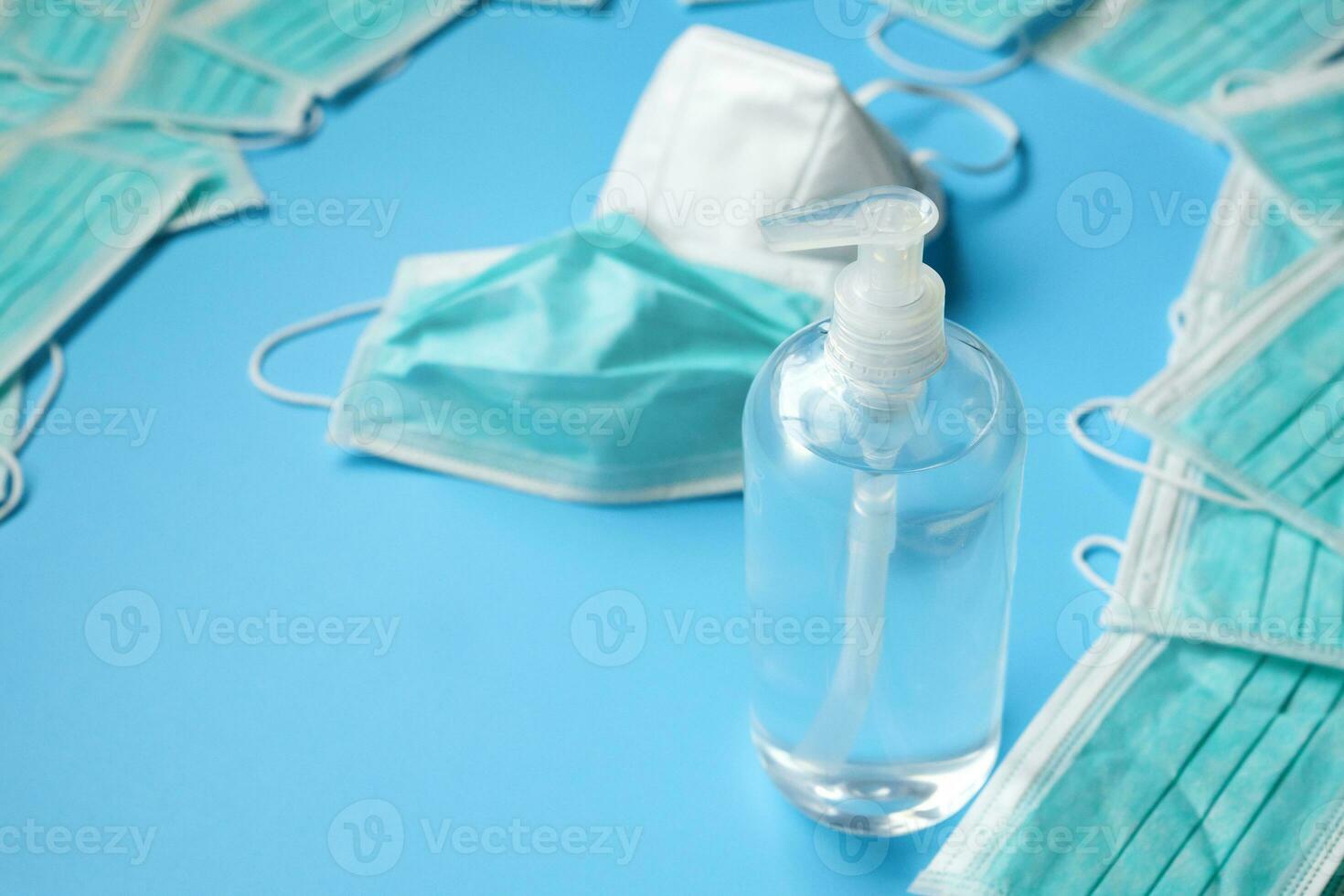 máscara facial médica kn95 com garrafa de lavagem das mãos de gel desinfetante de álcool em fundo azul conceito de prevenção de coronavírus covid-19 foto