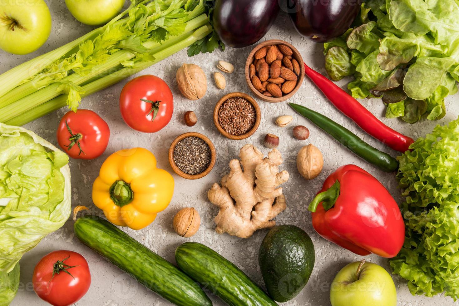 fundo de alimentos vegetais. uma variedade de legumes frescos, frutas, nozes, sementes em uma mesa cinza. uma dieta saudável. vitaminas. foto