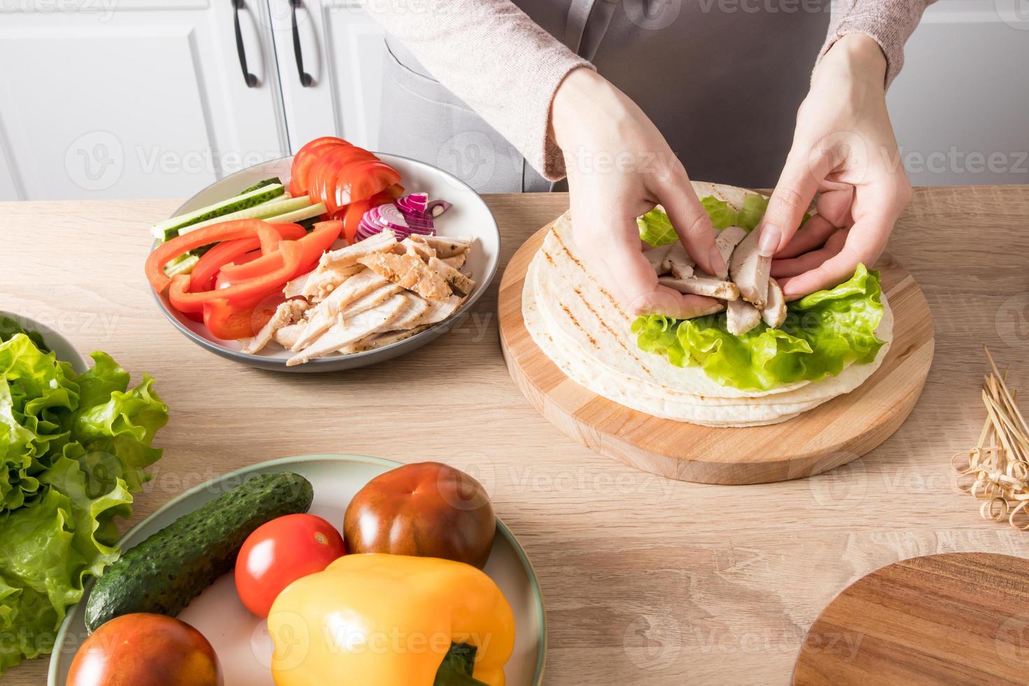 cozinhar tortilhas caseiras com frango e legumes frescos na mesa da cozinha em casa. delicioso almoço saudável, lanche. foto