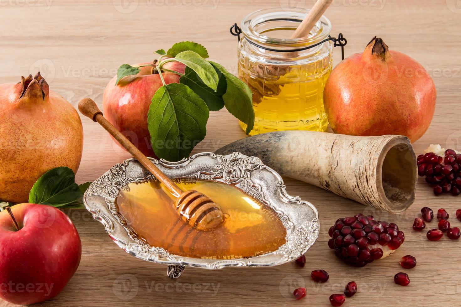 uma composição festiva do ano novo judaico de roshkasan. símbolos tradicionais do feriado - maçãs maduras, mel, romã. vista frontal. foto
