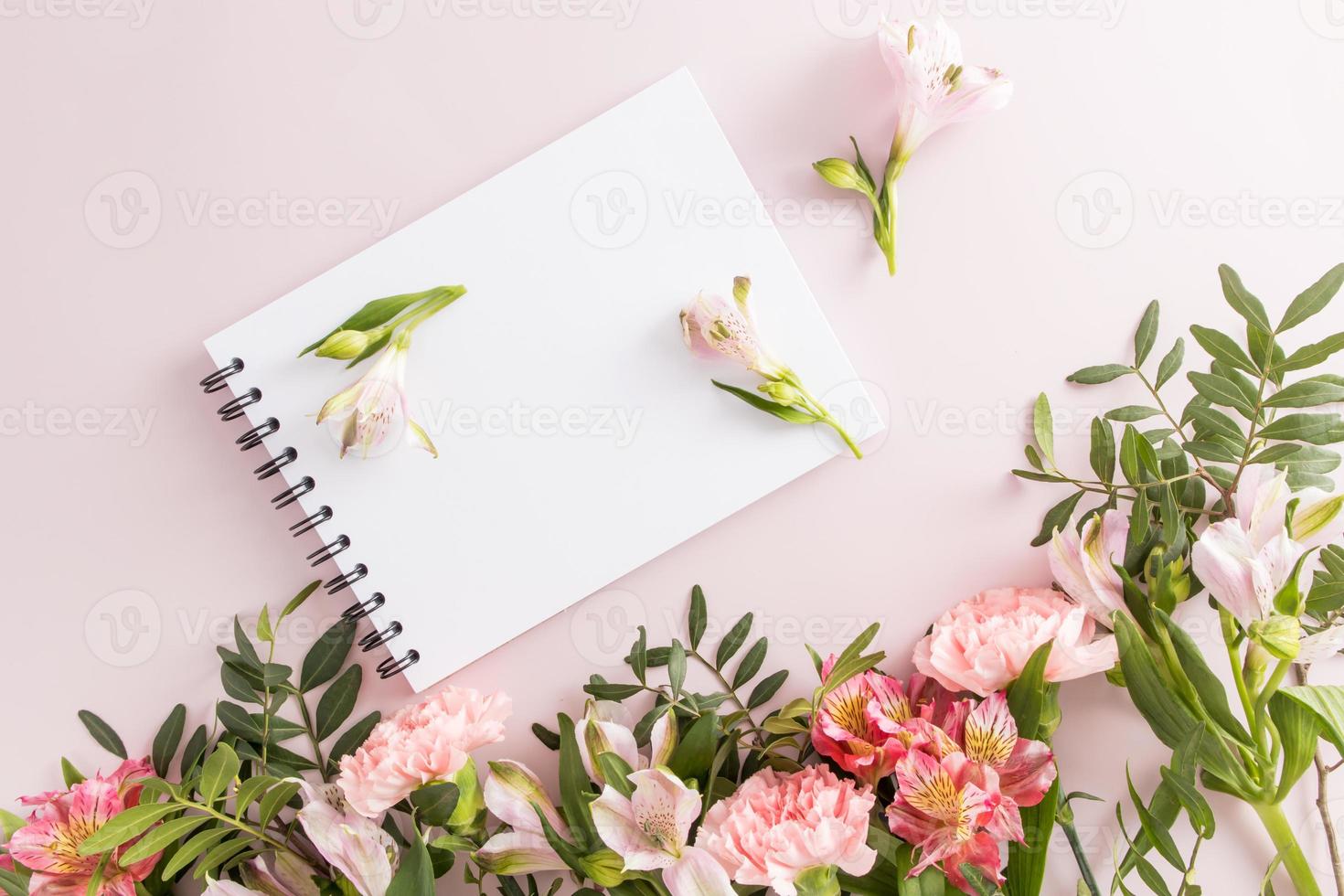composição de primavera com flores e um notebook em uma primavera preta com um espaço vazio para o seu texto. vista do topo. fundo pastel. foto
