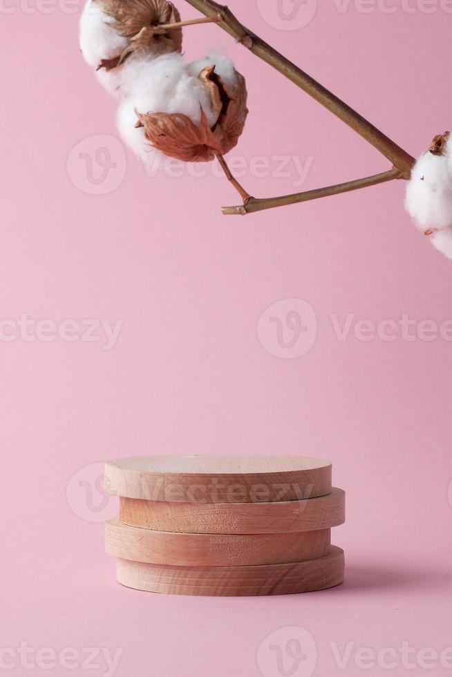 fundo cosmético com pódio de madeira e flores em rosa. vitrine vazia para apresentação de produtos cosméticos. foto