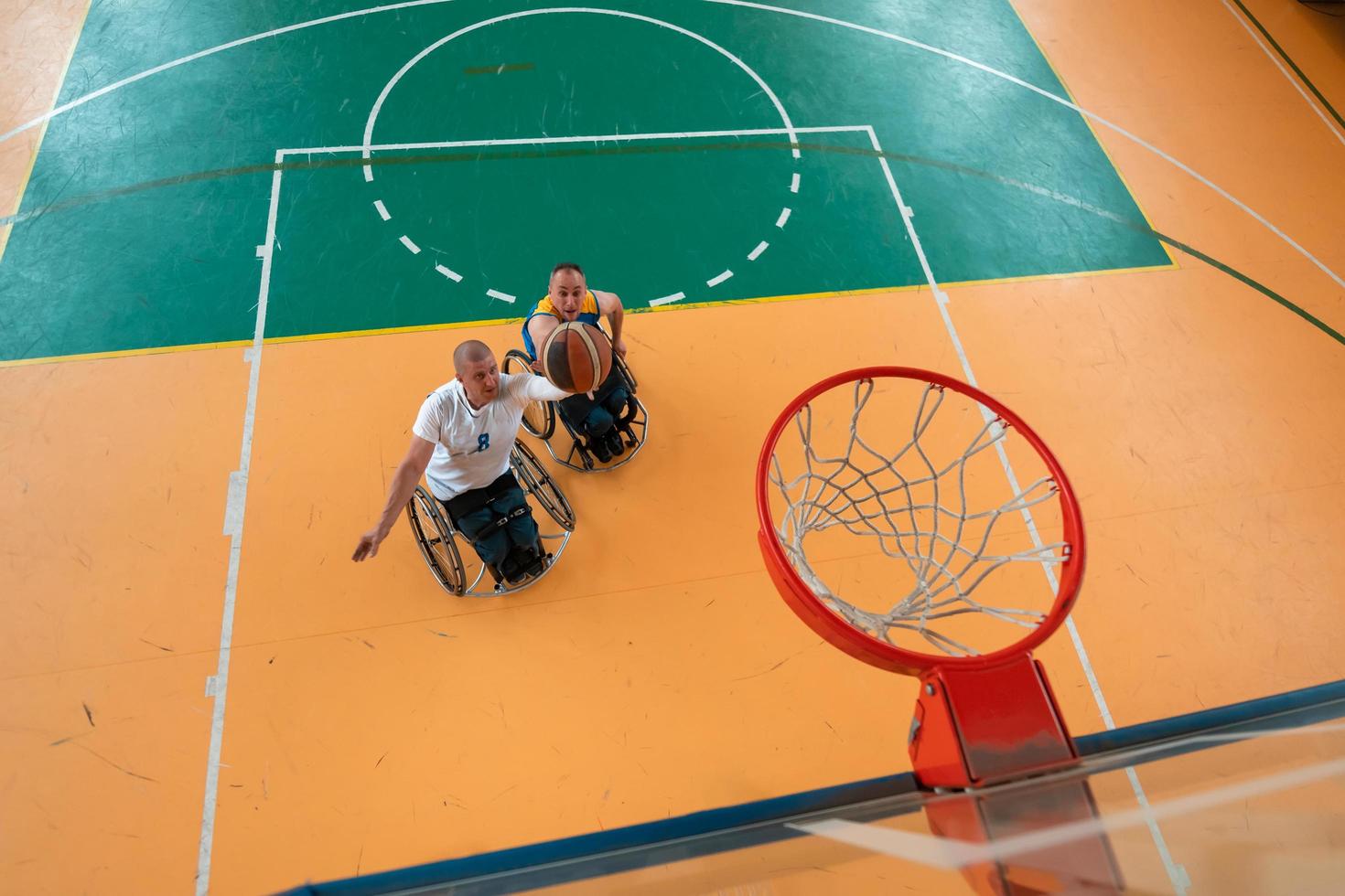 guerra com deficiência ou veteranos de trabalho mistos de raça e idade equipes de basquete em cadeiras de rodas jogando uma partida de treinamento em um ginásio de esportes. conceito de reabilitação e inclusão de pessoas com deficiência. foto