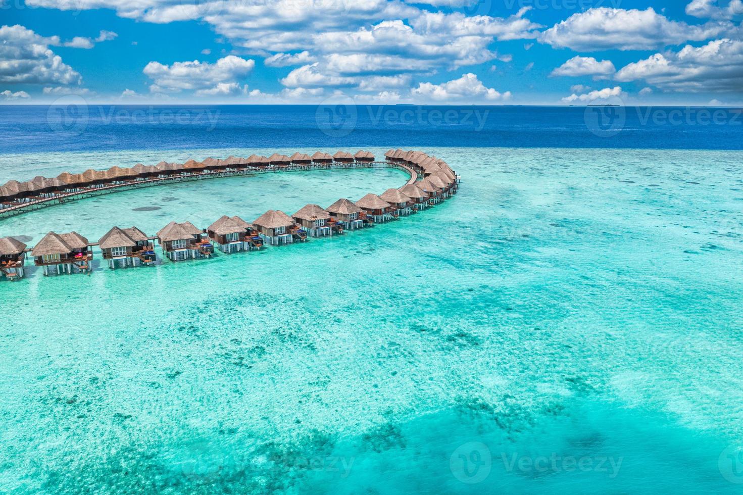 paisagem aérea perfeita, resort tropical de luxo com villas aquáticas. bela praia da ilha, palmeiras, céu ensolarado. incrível vista de olhos de pássaro nas maldivas, costa paradisíaca. turismo exótico, relaxar natureza mar foto