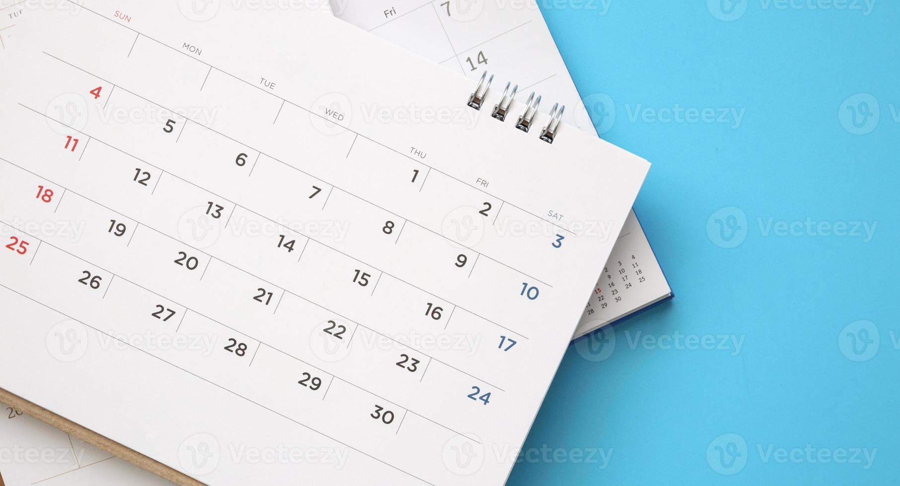 página do calendário fechar no conceito de reunião de compromisso de planejamento de negócios de fundo azul foto