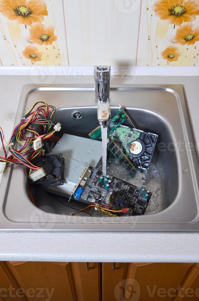 hardware na pia da cozinha sob o conceito metafórico de limpeza de computador de fluxo de água foto