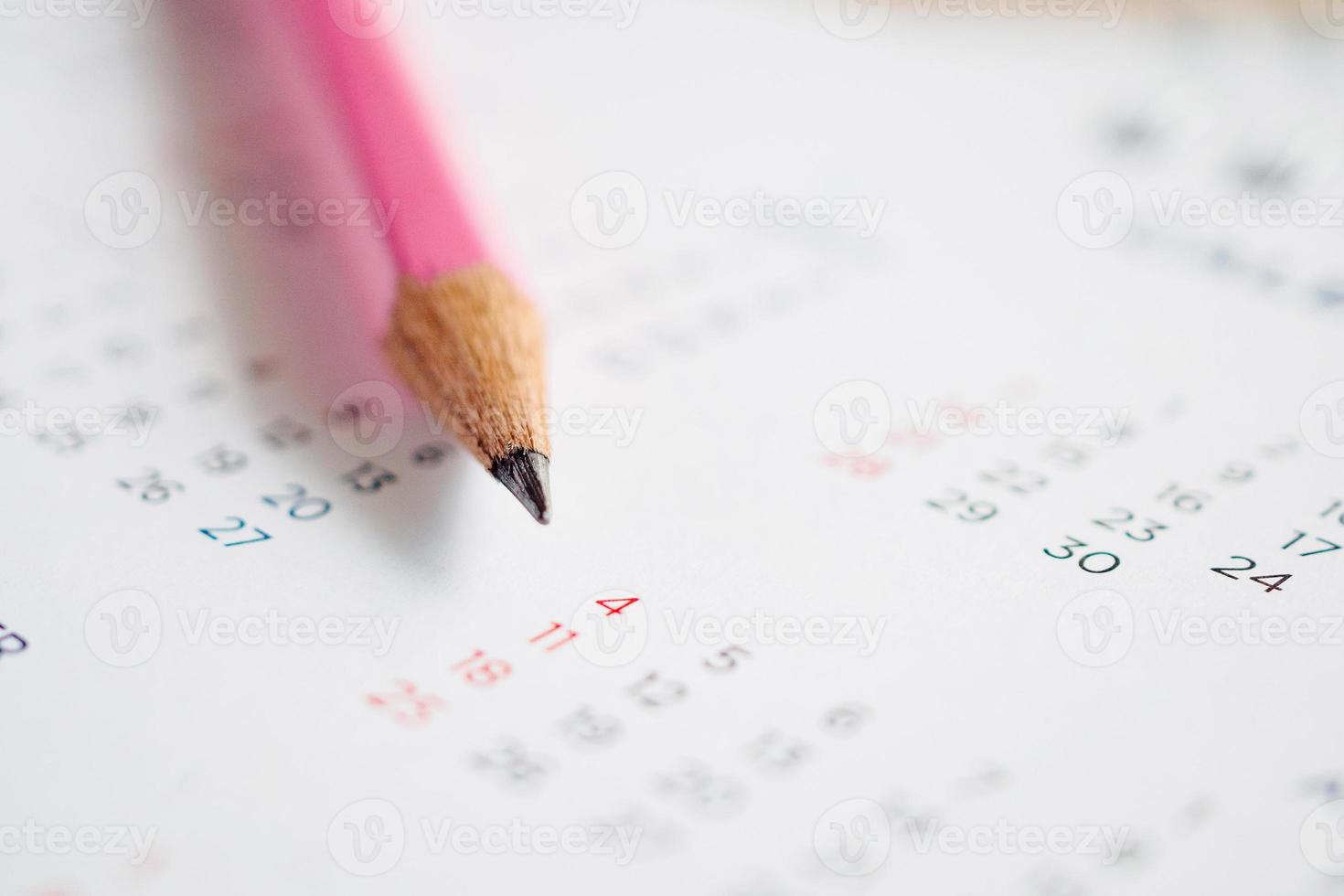 feche o lápis na página do calendário para marcar o conceito de planejamento de data foto