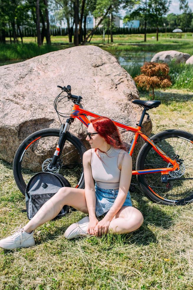 jovem mulher atraente está descansando após o passeio de bicicleta. estilo de vida ativo, esportes foto