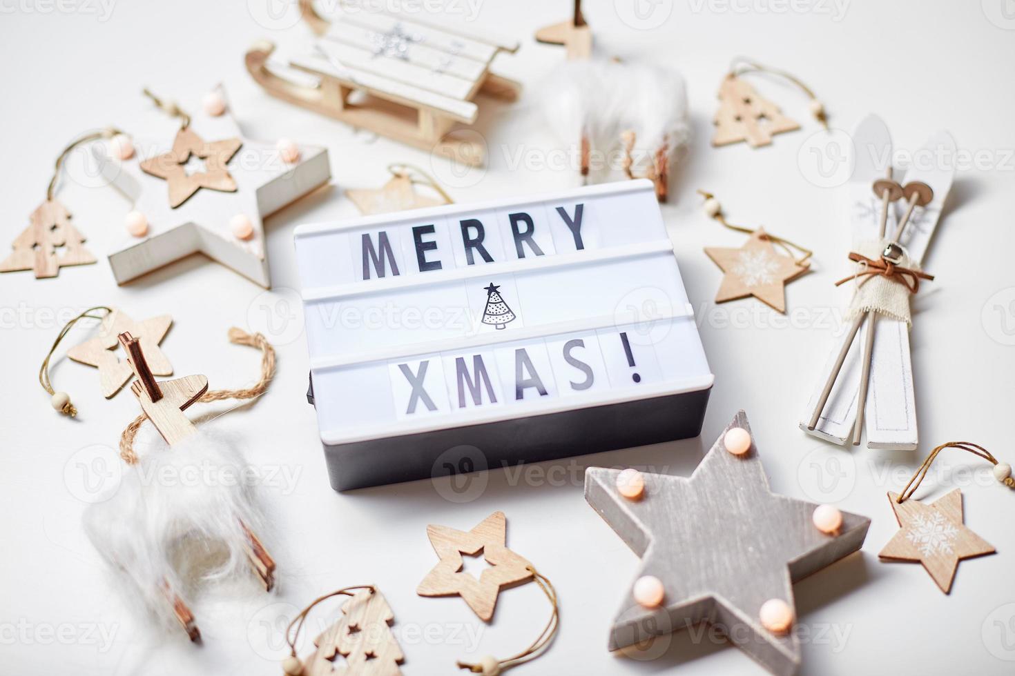 inscrição de caixa de luz feliz natal e enfeites de madeira foto