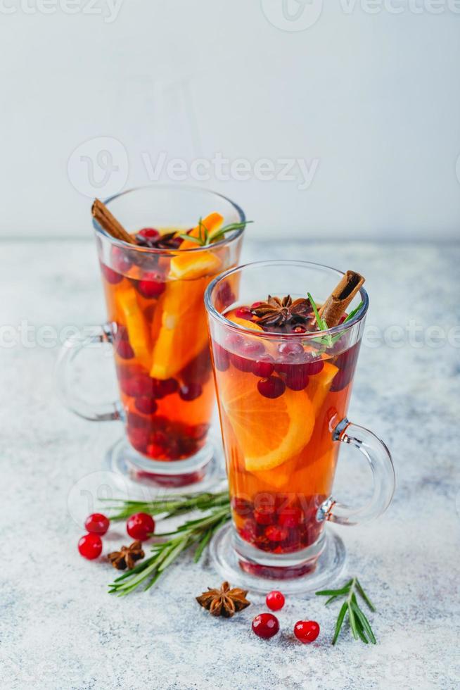 bebidas de laranja e cranberry com fatias de laranja e especiarias. bebidas quentes para o inverno e natal foto