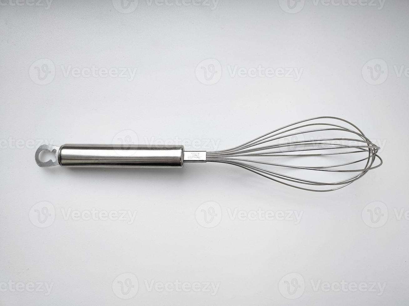 batedor de aço inoxidável em fundo branco. utensílio de cozinha foto