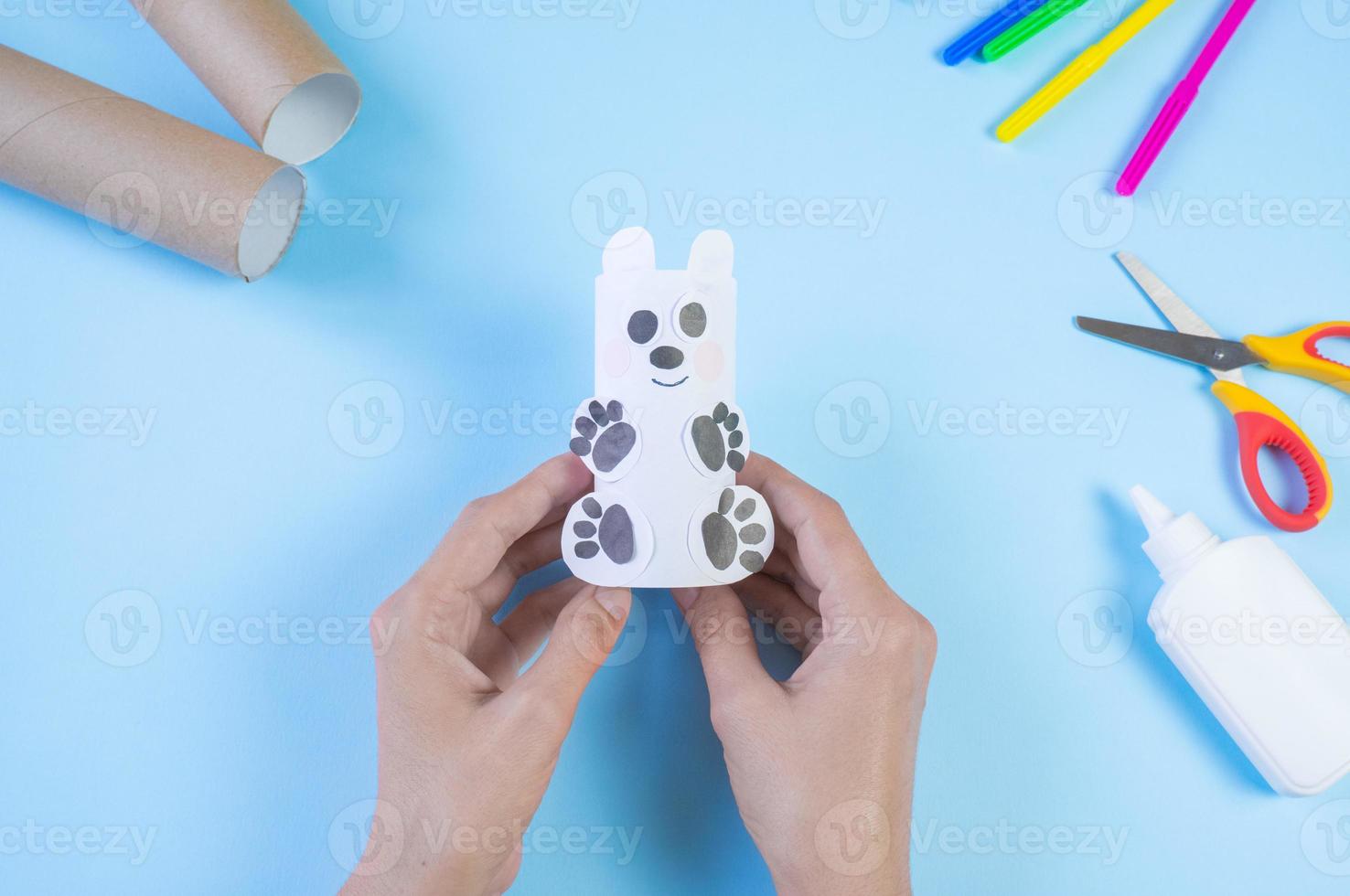 artesanato diy fácil festivo para crianças. rolo de urso de brinquedo de papel higiênico em um fundo azul. decoração criativa ecologicamente correta, reutilização, reciclagem, conceito artesanal sem desperdício mínimo foto