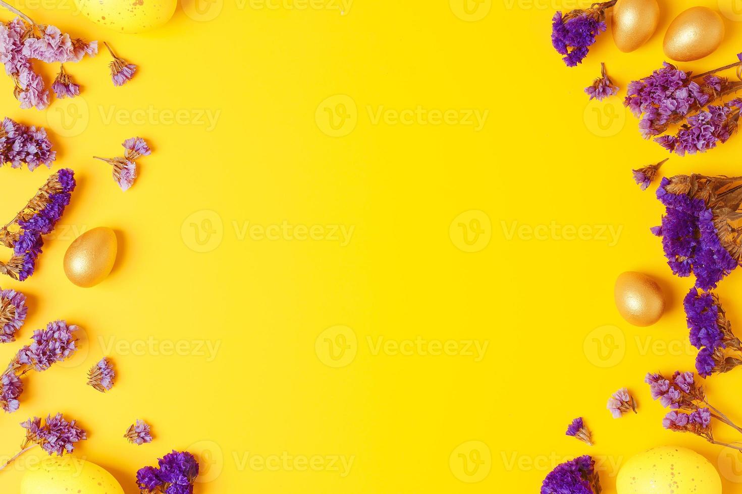 ovos de páscoa amarelos com flores roxas sobre fundo amarelo. postura plana, copie o espaço. foto