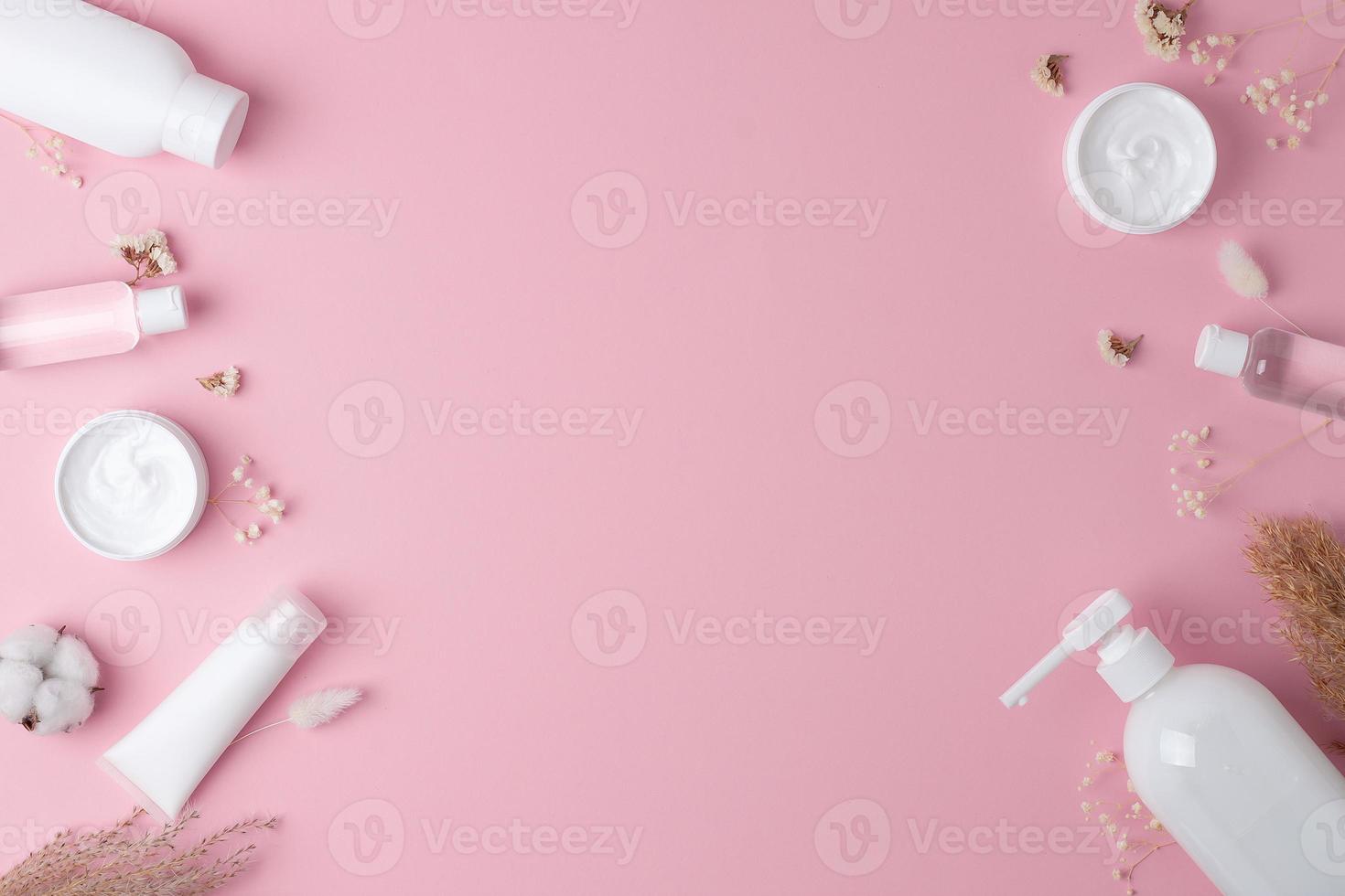 fundo cosmético com produtos de cuidados com a pele em rosa. postura plana, copie o espaço foto