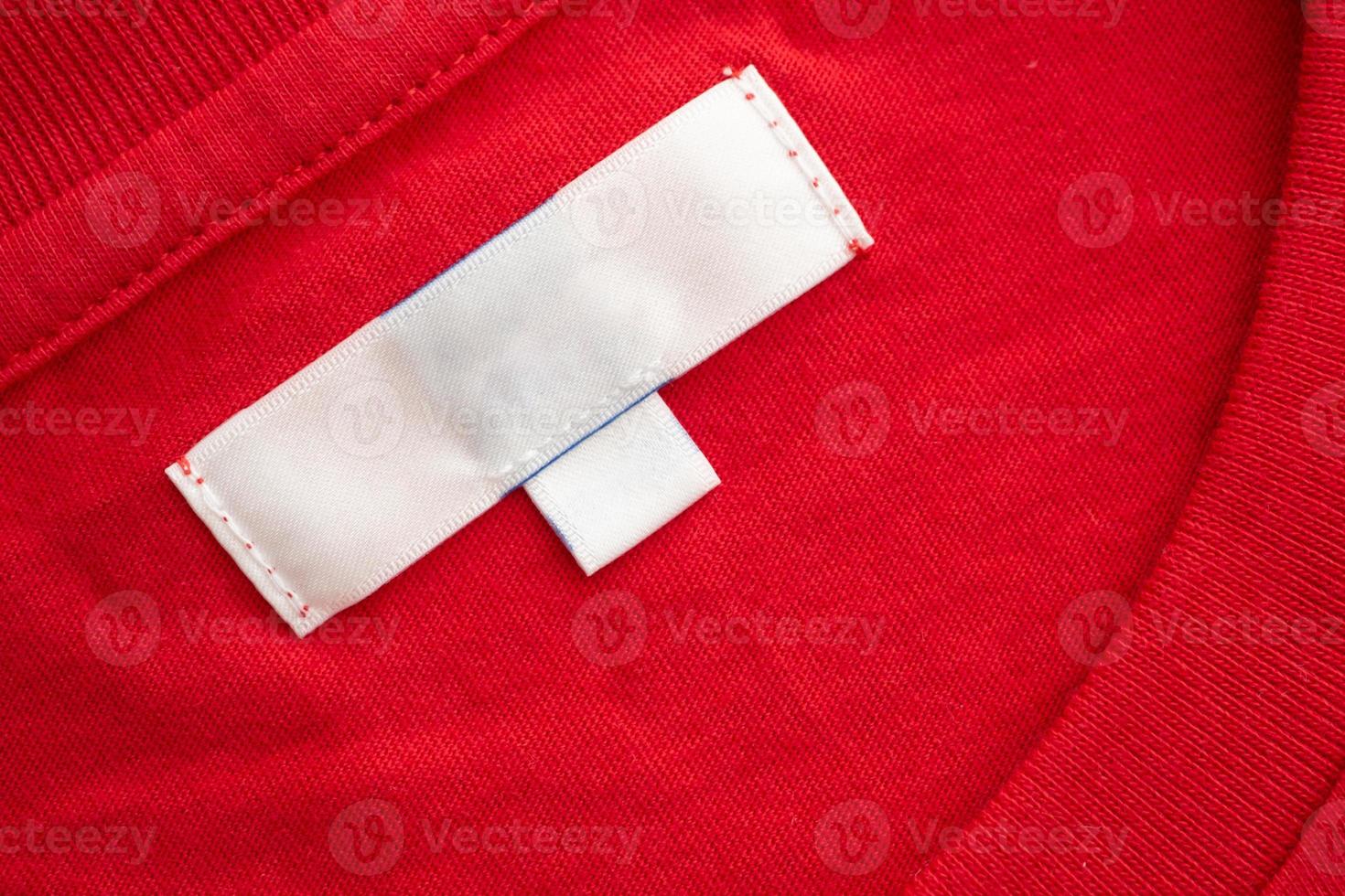 etiqueta de etiqueta de roupa em branco branca no novo fundo de textura de tecido de camisa de algodão vermelho foto