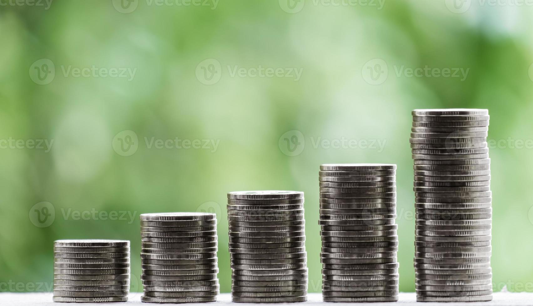finanças de negócios e conceito de dinheiro, economizar dinheiro para preparar no futuro árvore crescendo na moeda de empilhamento com fundo verde bokeh foto