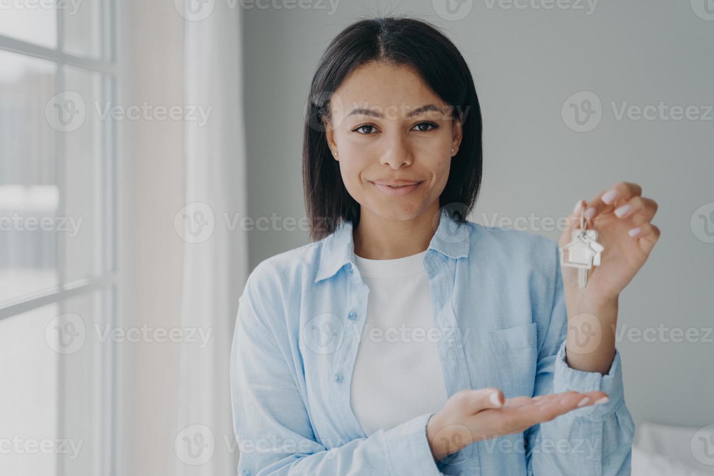 agente imobiliário feminino mostrando as chaves para a nova casa, oferecendo apartamento. venda de habitação, hipoteca foto