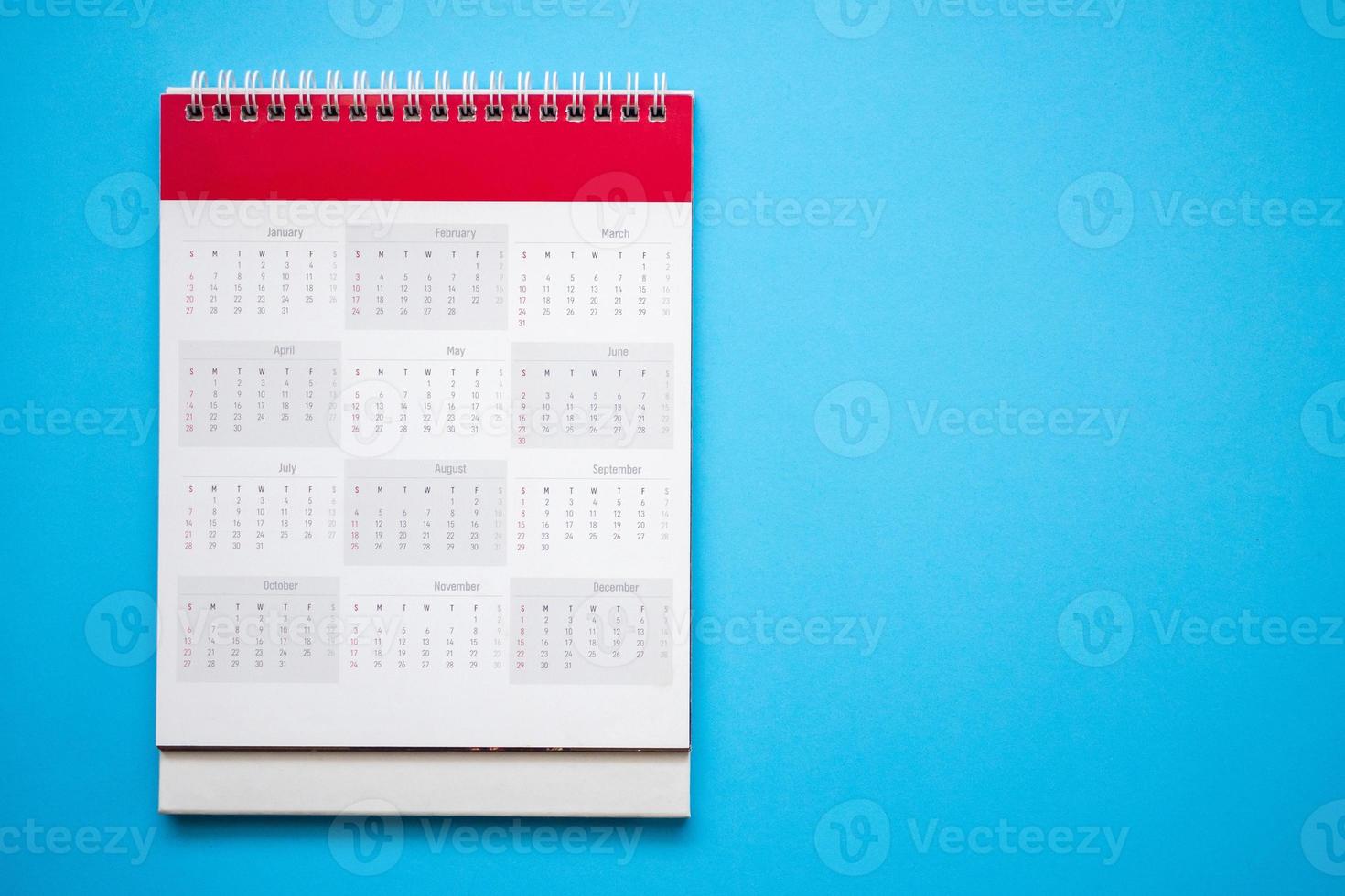 página de calendário no conceito de reunião de compromisso de planejamento de negócios de fundo azul foto