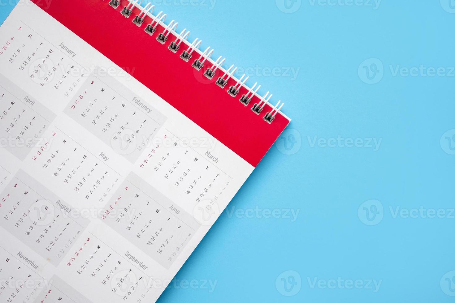 página de calendário no conceito de reunião de compromisso de planejamento de negócios de fundo azul foto