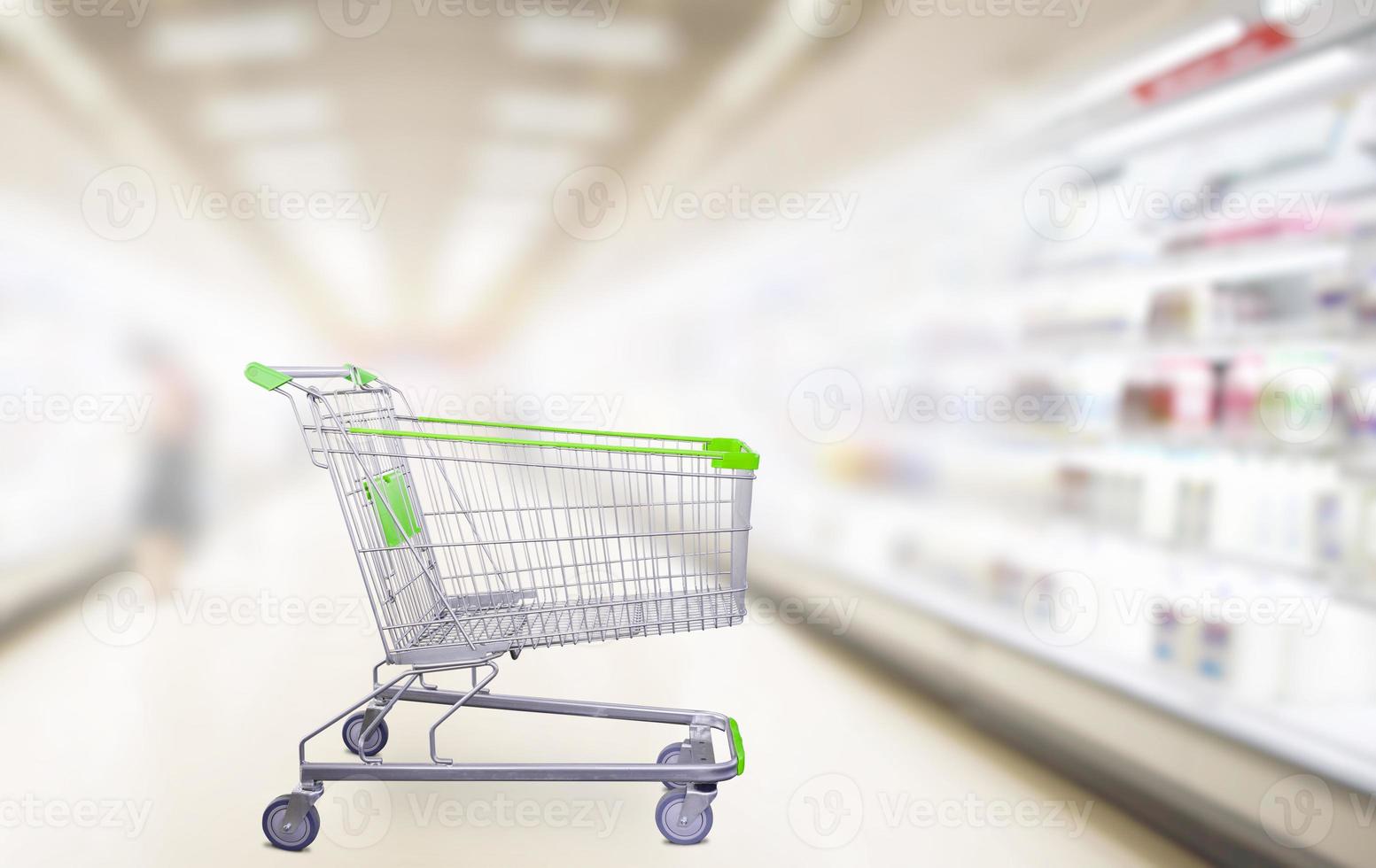 carrinho de compras verde vazio no corredor do supermercado foto