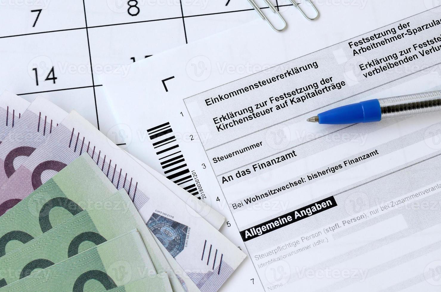 formulário de imposto alemão com caneta e contas de dinheiro europeias encontra-se no calendário do escritório. contribuintes na alemanha usando moeda euro para pagar impostos foto