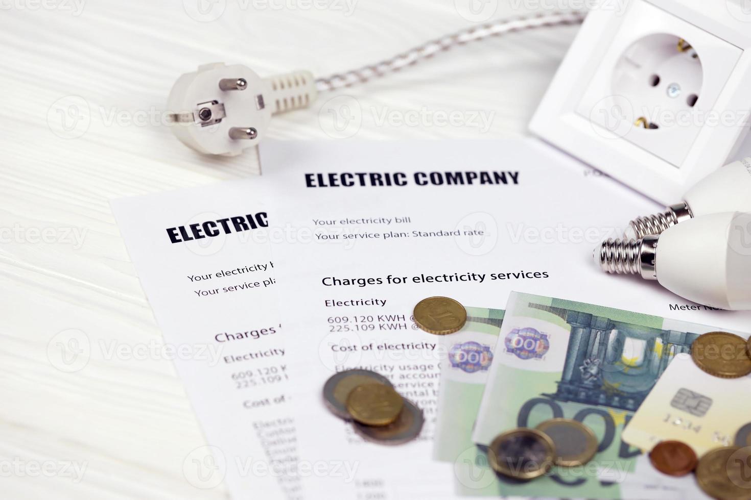 calculadora e notas de euro com caneta na conta de eletricidade europeia. conceito de economizar dinheiro usando lâmpadas led de economia de energia e pagamento de contas elétricas foto