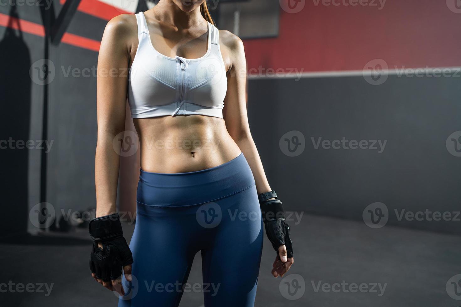 close-up tiro no músculo do estômago abdominal de mulheres adultas baleadas dentro do ginásio de boxe fitness. estilo de vida saudável para pessoas que treinam e treinam dentro da academia com espaço de cópia. foto