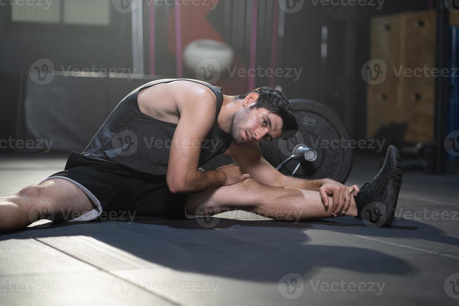 homens caucasianos adultos bonitos se aquecem e se alongam antes de fazer exercícios de crossfit dentro da academia de ginástica para treinar a força do corpo e os músculos dos braços firmes e a boa saúde do corpo físico. foto