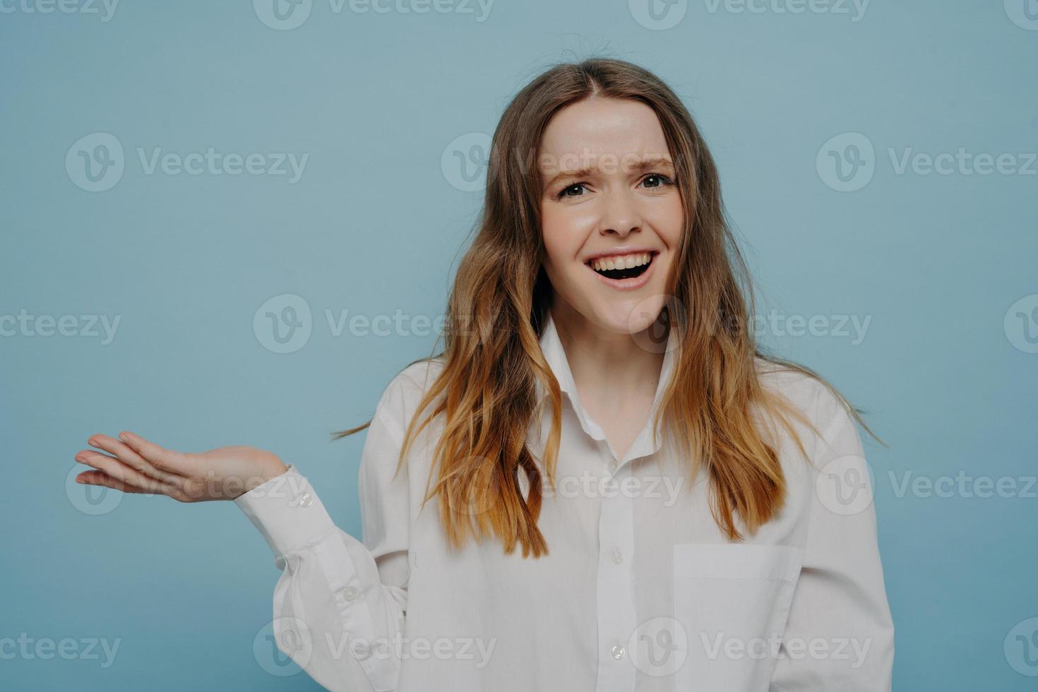 jovem feliz na camisa branca apresentando algo por lado foto