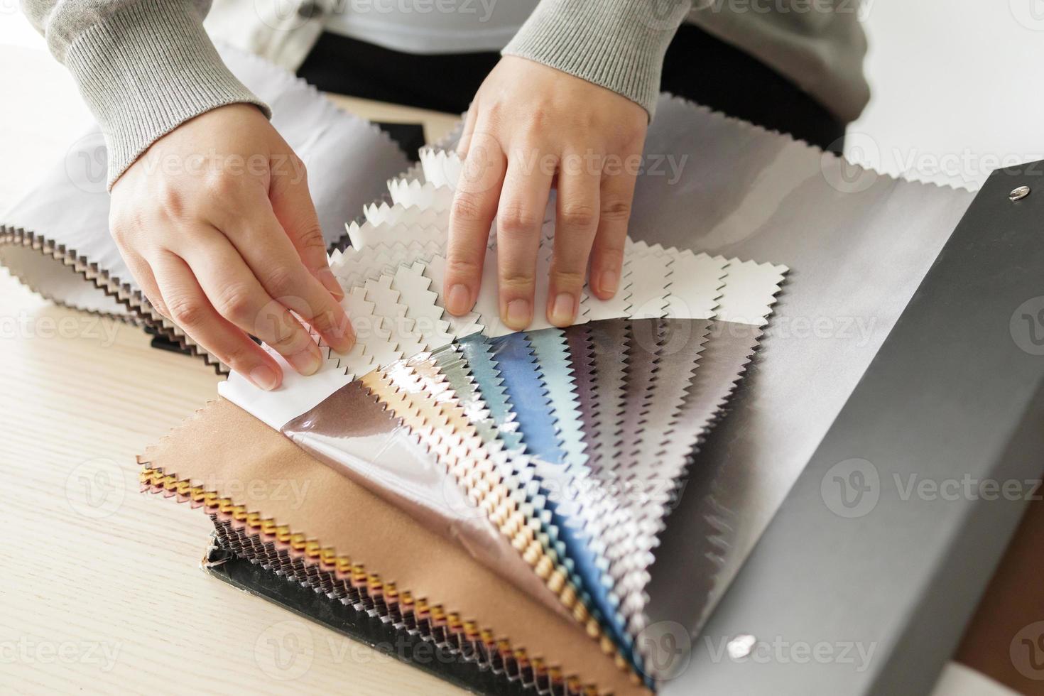 designer feminino com amostras de cores de tecido escolhendo têxteis para cortinas foto