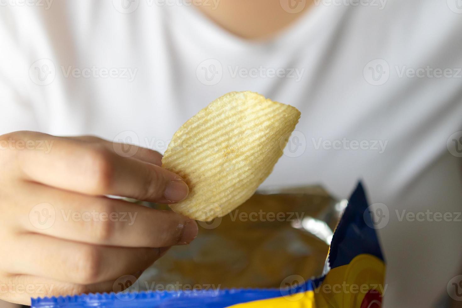 mão segure batatas fritas com saco de lanche foto