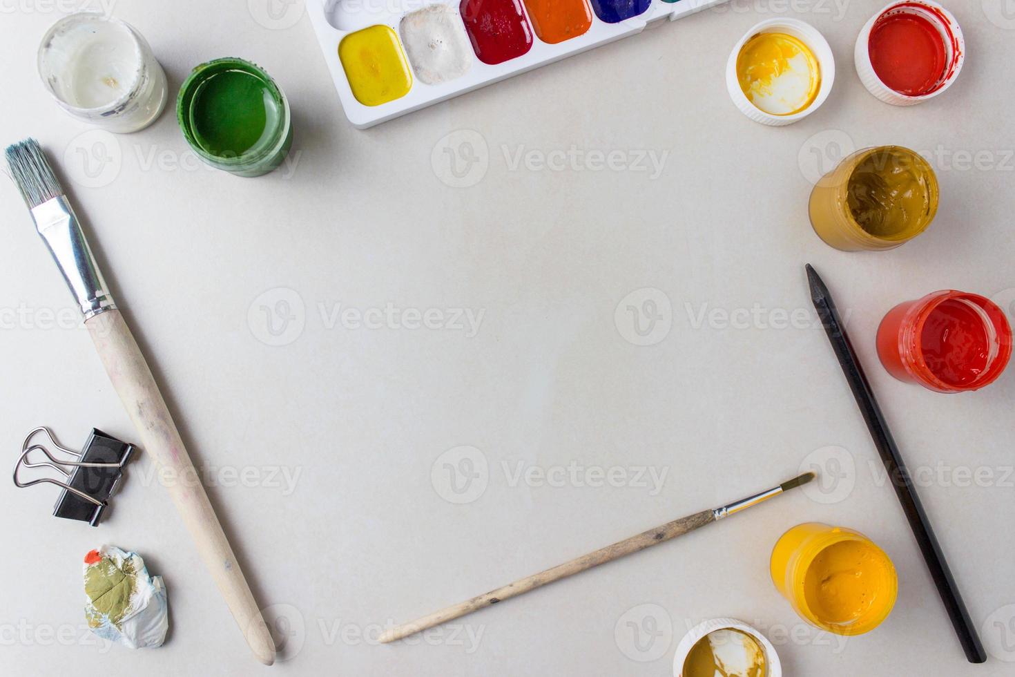 artista flatlay com espaço de cópia. pincéis, guache e tintas aquarela estão sobre a mesa. com um lugar para texto foto