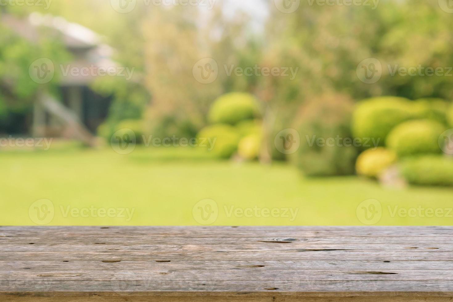 tampo de mesa de madeira vazio com fundo de jardim de parque de borrão abstrato foto