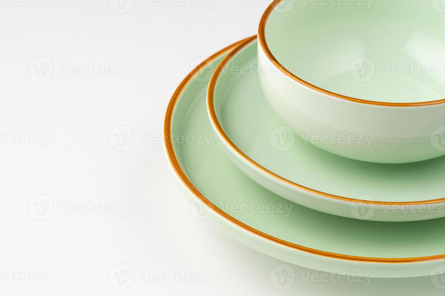 um conjunto de talheres de cerâmica verde pastel com contornos laranja. fechar-se foto