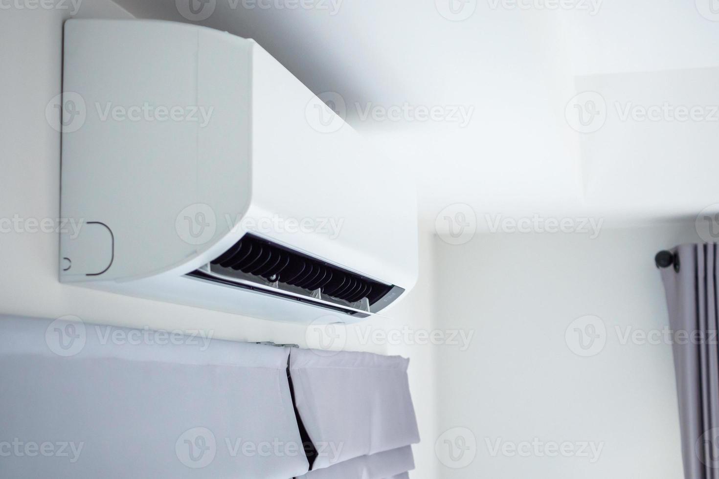 condicionador de ar no fundo interior do quarto de parede branca foto