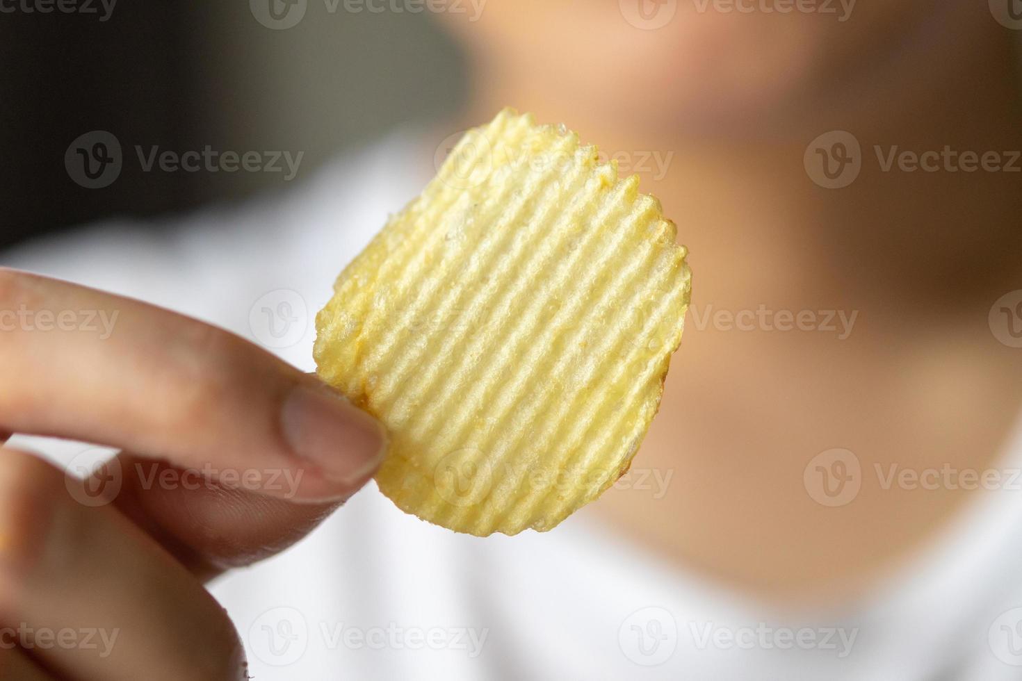 mão segure batatas fritas prontas para comer foto