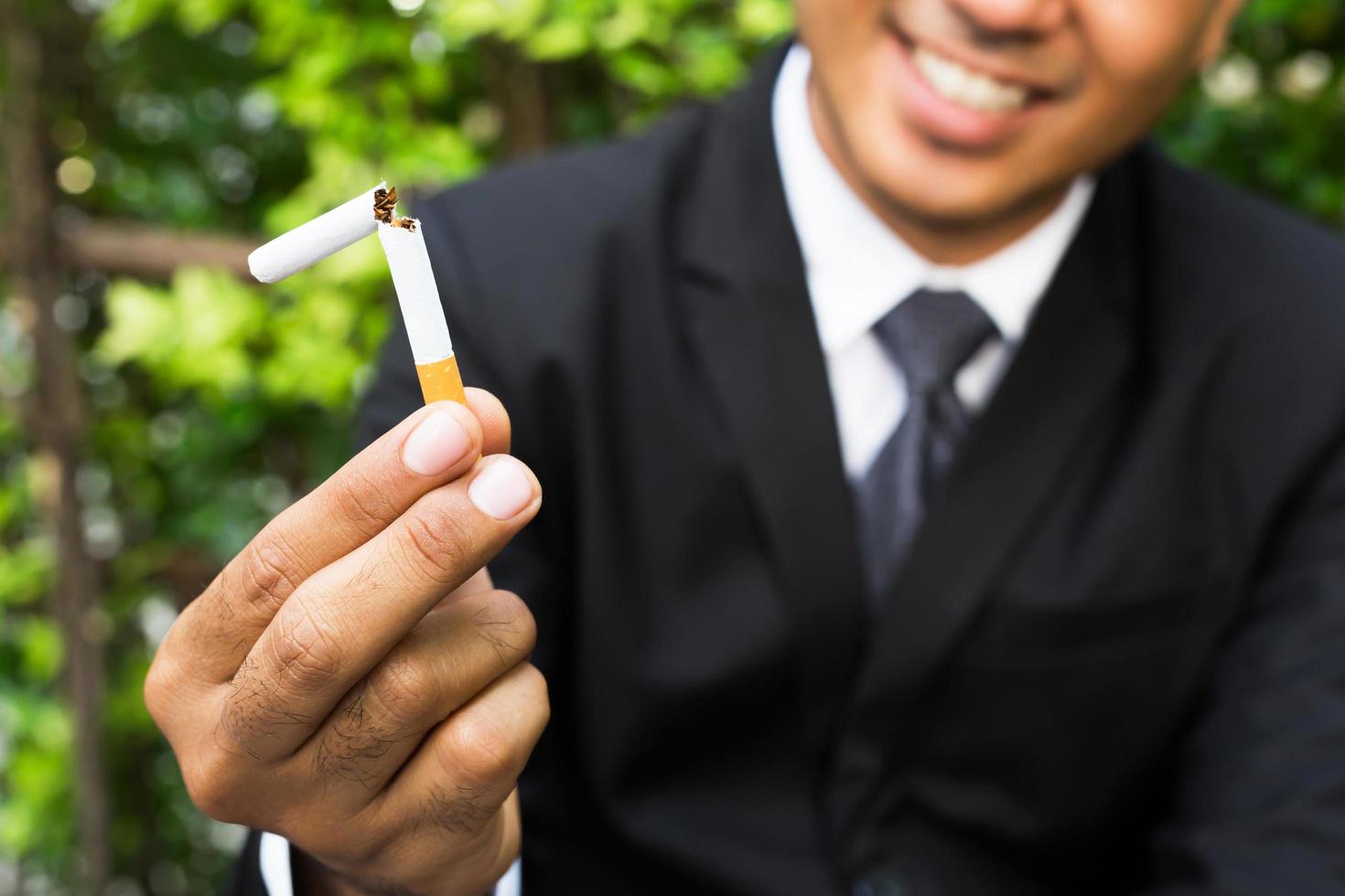 homem recusando o conceito de cigarros para parar de fumar e fundo escuro estilo de vida saudável. ou conceito de campanha sem fumar. foto