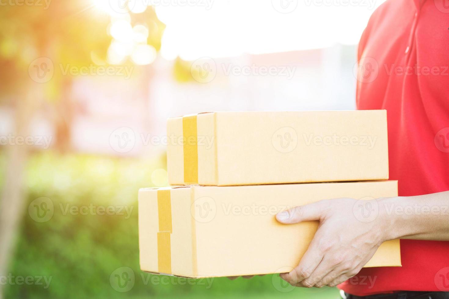 entregador de encomendas de um pacote através de um serviço. pronta entrega cliente aceitando uma entrega de caixas do entregador postal. foto