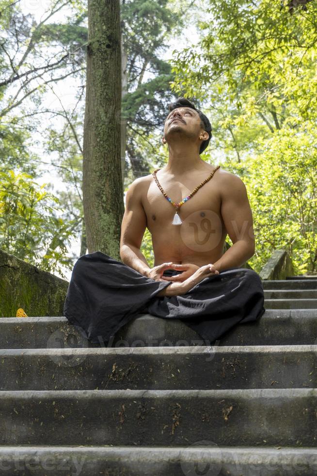 jovem fazendo meditação em uma escada em uma floresta, méxico foto