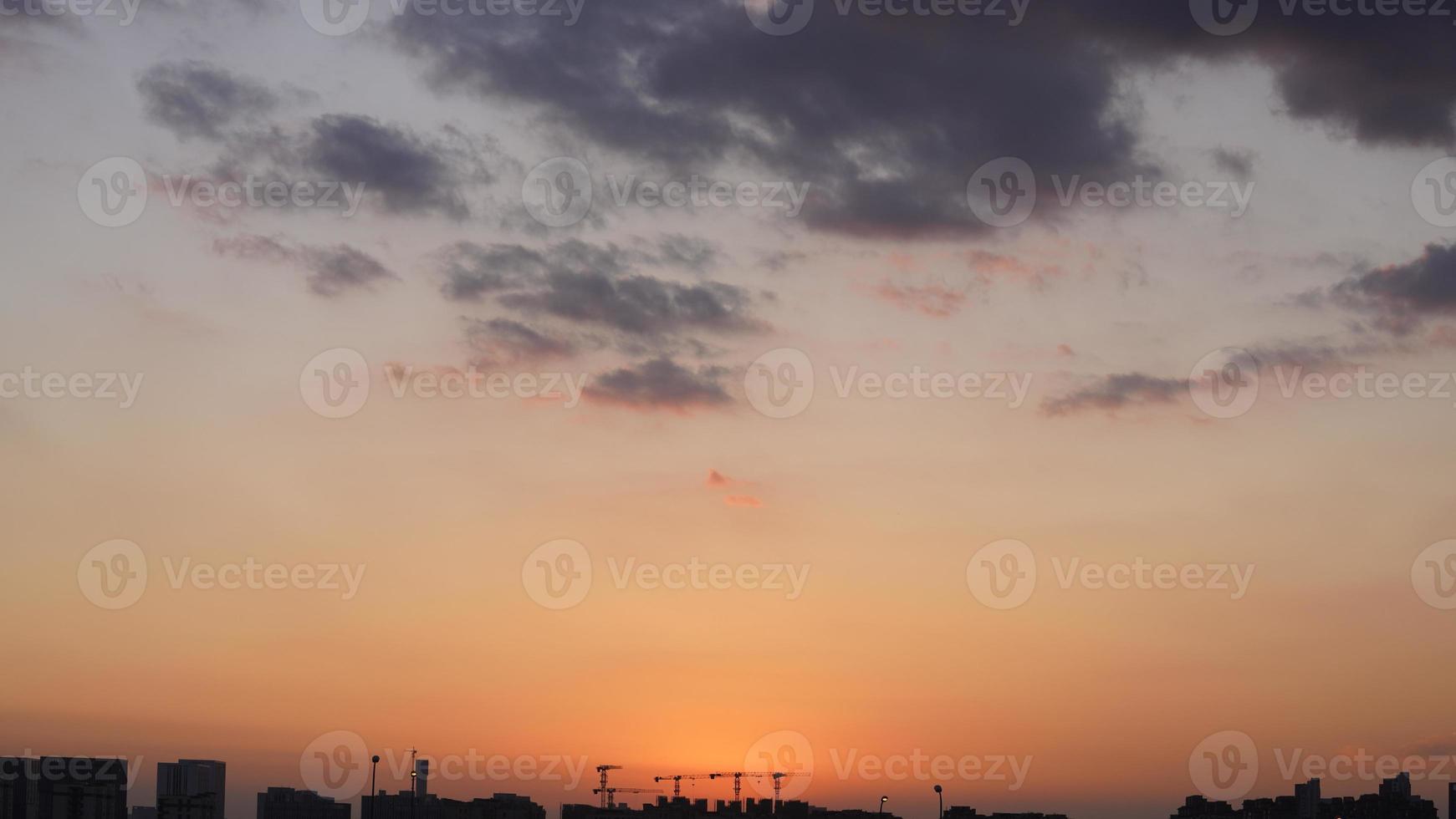 a bela vista do pôr do sol com as nuvens coloridas e o céu da cidade foto